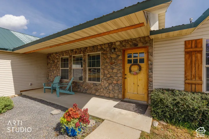 Stone veneer facade with wood-paneled entry door, covered porch, and siding accents
