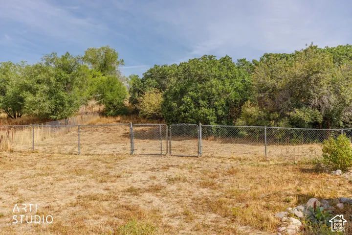 Fenced yard with natural landscaping and mature trees