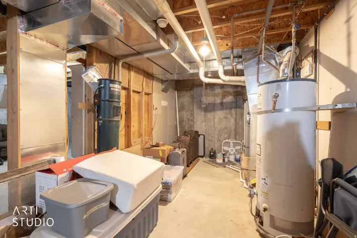 Exposed ductwork, water heater, and unfinished walls