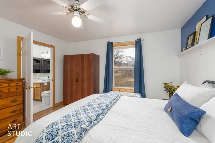 Hardwood-style flooring throughout, ceiling fan with integrated lighting, and a window with mountain scenery