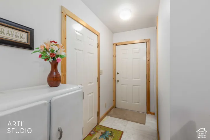 Entryway featuring two paneled doors with natural wood trim and a flush-mount ceiling light