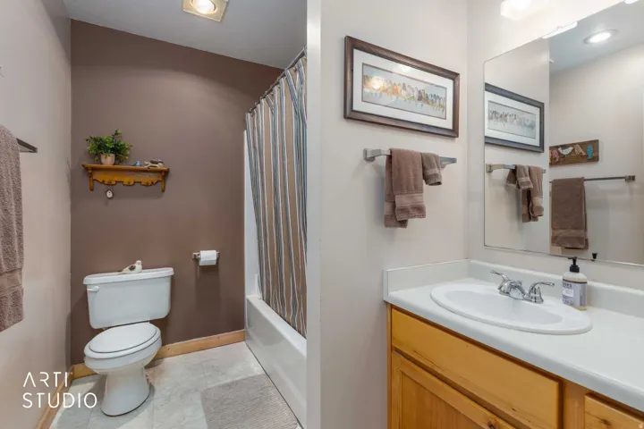Bathroom featuring a vanity with wood cabinetry, a white countertop, and an integrated sink
