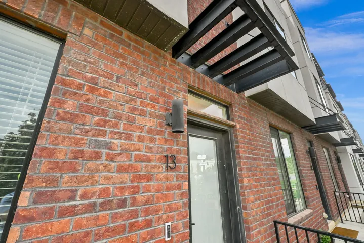 Brick exterior facade with a black metal awning and exterior sconce