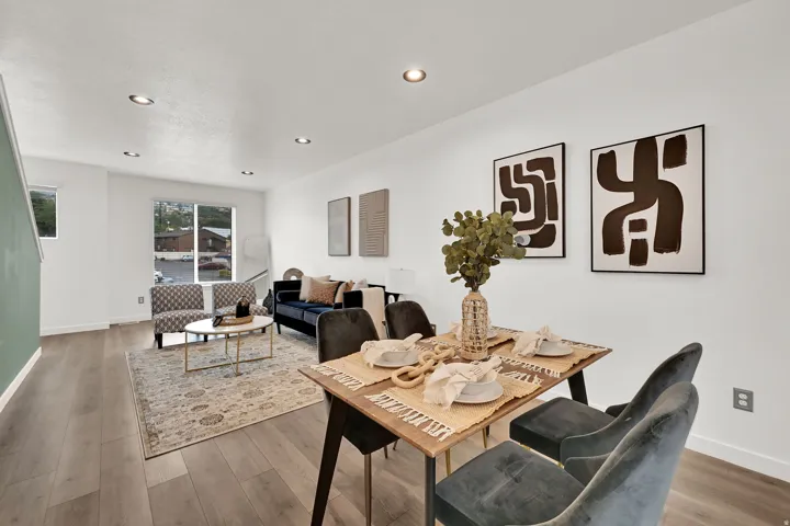 Recessed ceiling lighting, light wood-finish flooring, white wall paint, and a large window