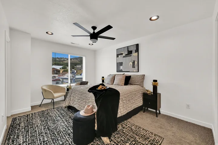 Recessed lighting, ceiling fan, expansive window, neutral wall paint, and carpeted flooring