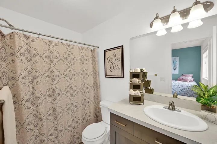 Spa-inspired bathroom featuring a curved vanity with white solid-surface countertop, brushed nickel faucet, and ample storage