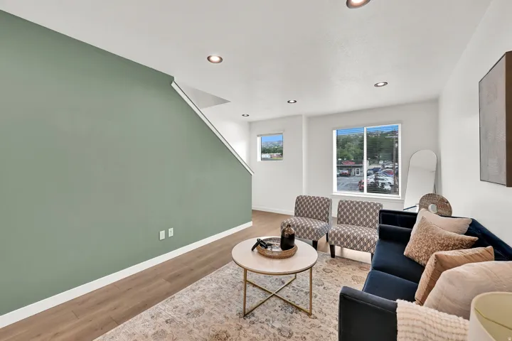 Recessed lighting, wood-finish flooring, white trim, and multiple windows creating bright interiors