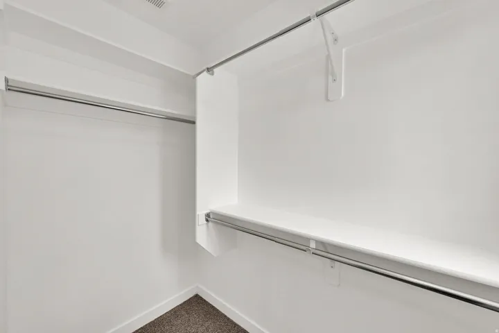 Built-in shelving with chrome hanging rods