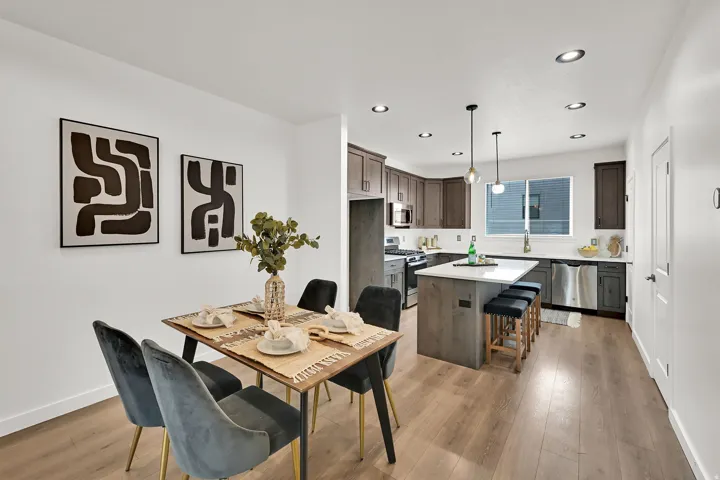 Open-concept living space with wood-finish flooring, recessed lighting, and a kitchen featuring a center island, stainless steel appliances, and ample cabinetry