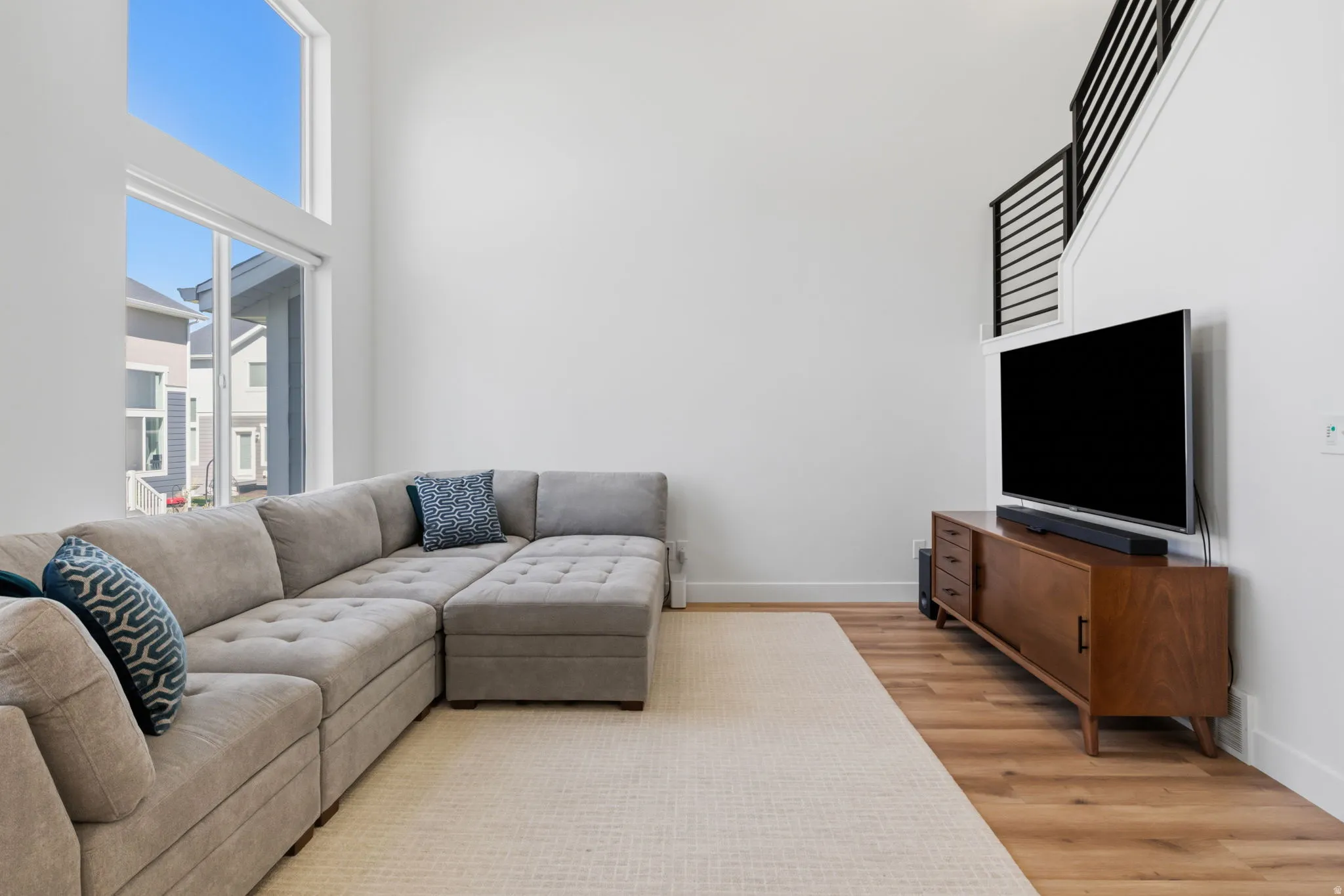 Expansive living space featuring high ceilings, large windows, and wood-finish flooring