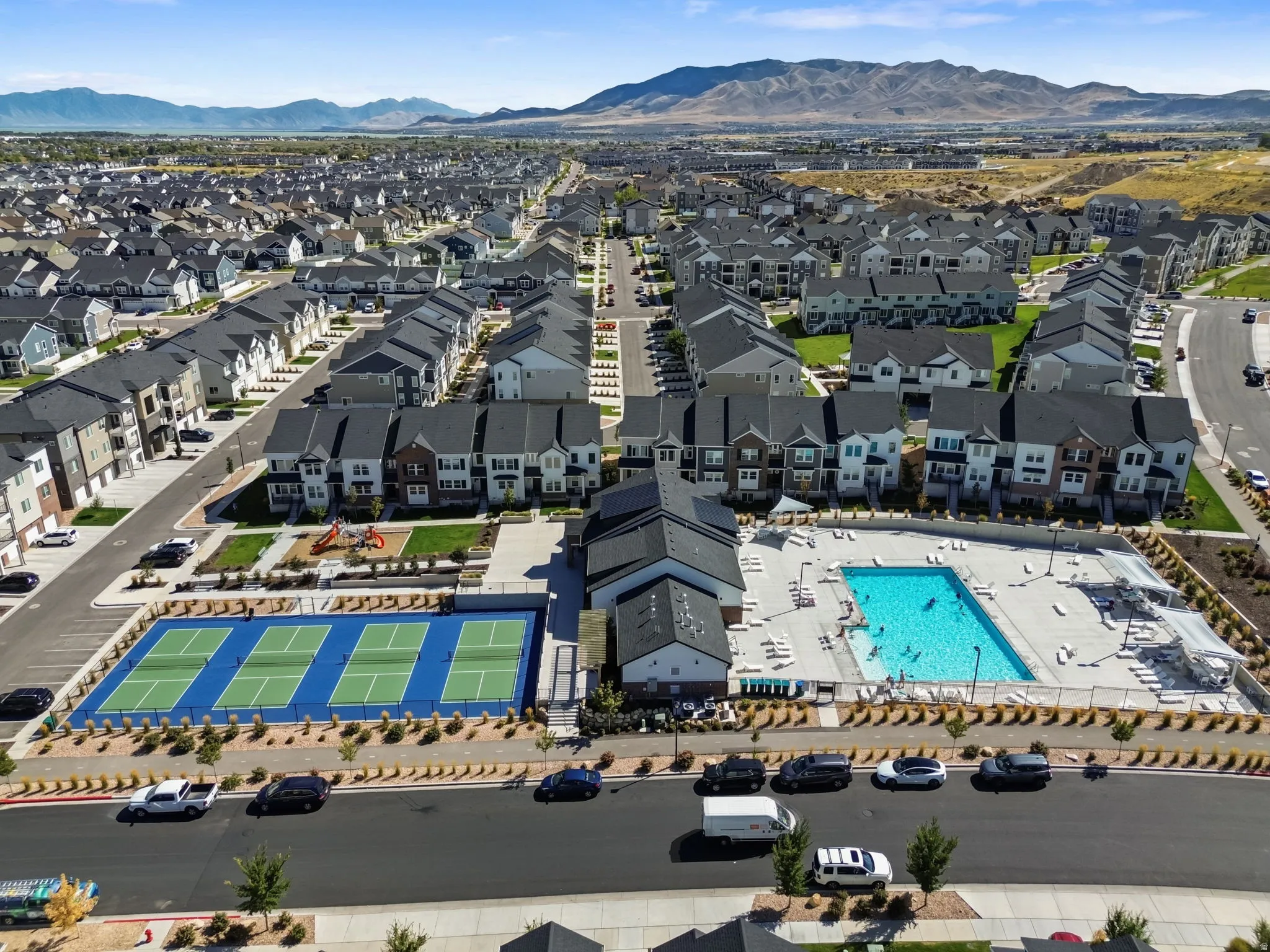 Community features a swimming pool, multiple tennis courts, a playground, and mountain scenery