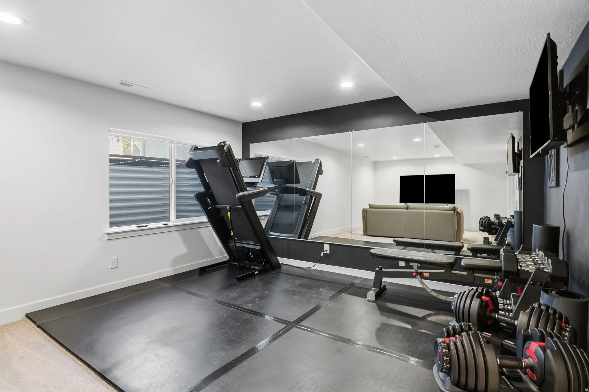 Recessed lighting, wall-mounted mirror, and a window with a corrugated metal window well