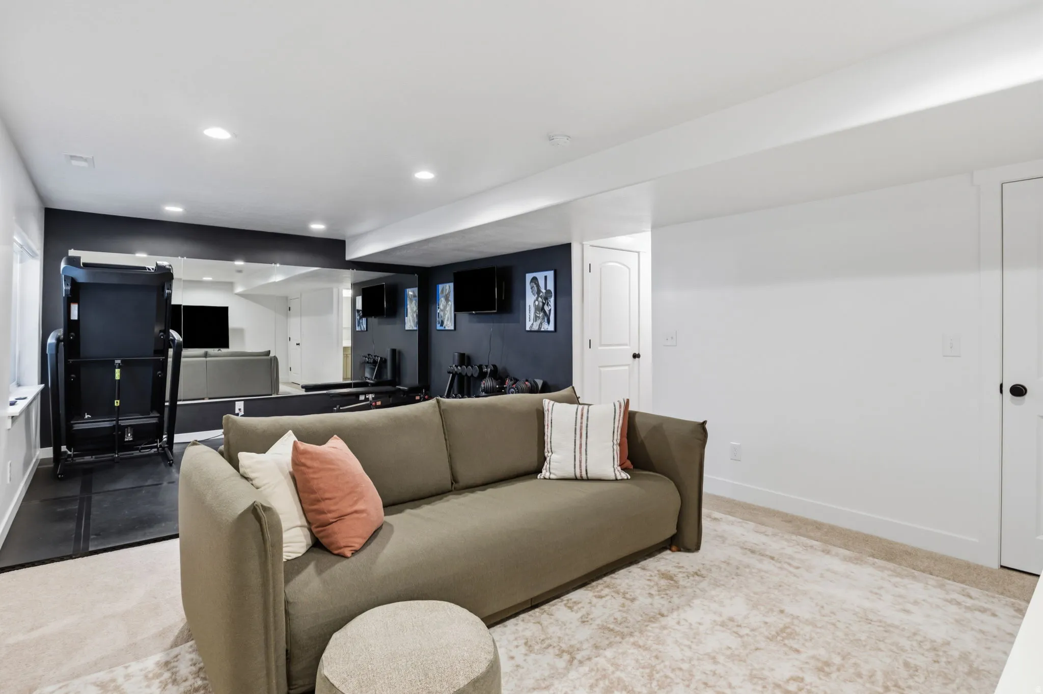 Recessed ceiling lighting, full-wall mirrors, light-toned carpeting, white interior doors with black hardware, and dark accent walls