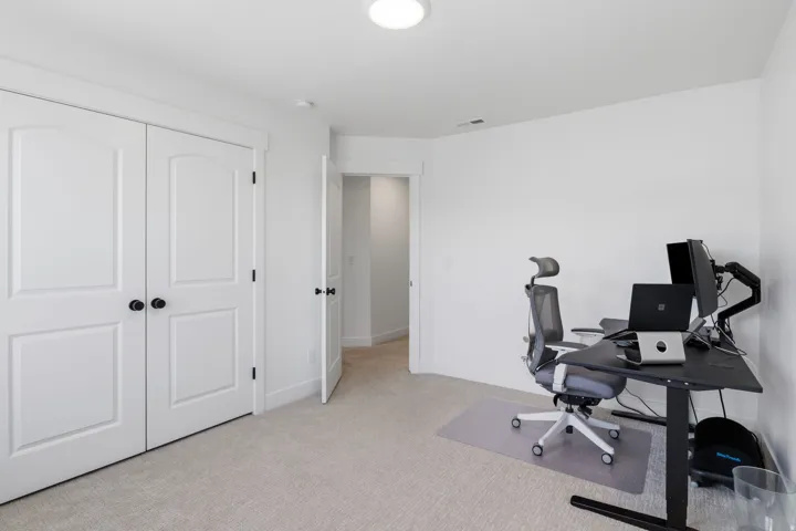 Neutral tone interior with light colored carpeting, white walls, and a recessed ceiling light fixture