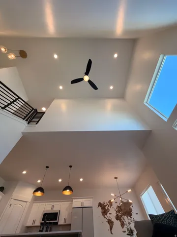 Soaring ceilings featuring a skylight and recessed lighting