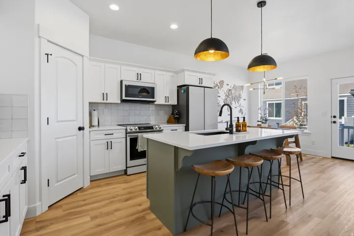 Kitchen featuring white cabinetry, wood-finish flooring, recessed lighting, and a kitchen island with pendant lighting