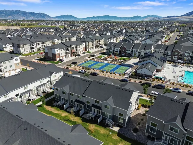 Mountain backdrop, community tennis courts, swimming pool, and multiple residential buildings
