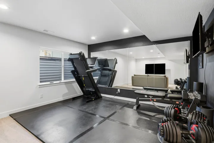 Recessed lighting, wall-mounted mirror, and a window with a corrugated metal window well