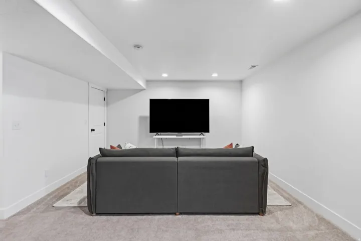 Recessed lighting throughout, light-toned carpeted flooring, and white walls