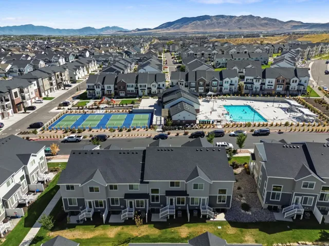 Community with extensive residential properties, sports courts, swimming pool, and mountain backdrop