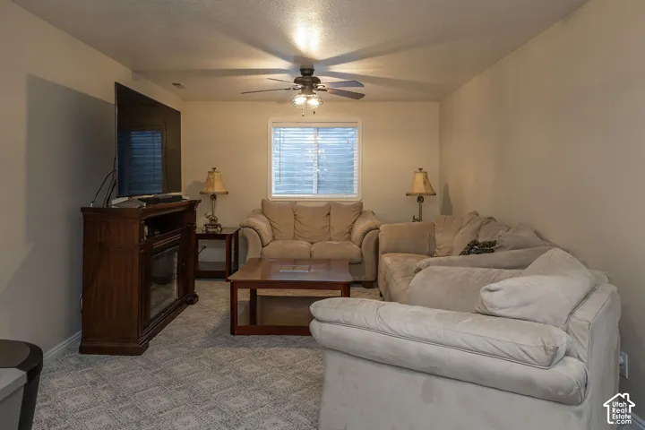 Ceiling fan, window with blinds, and neutral wall paint.