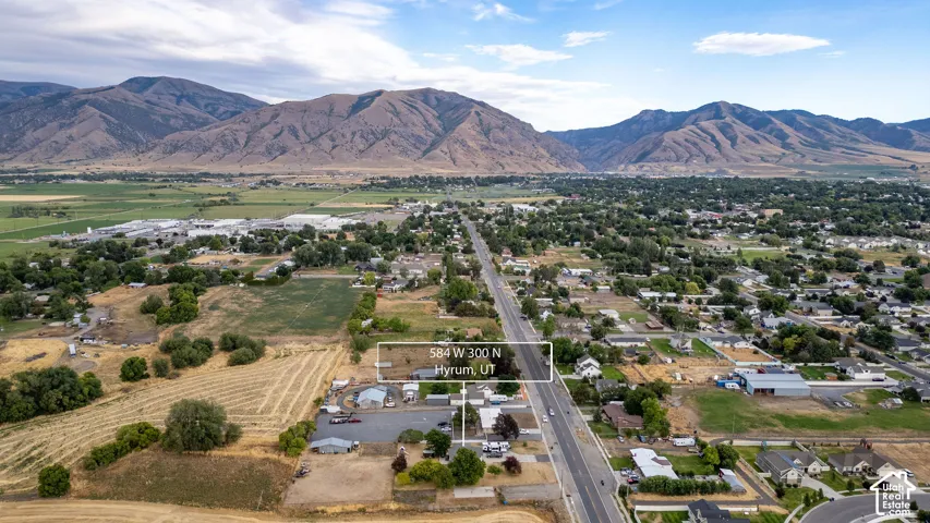 Additional aerial view with expansive rural landscape, distant mountains, agricultural fields, and residential areas of home surrounding residence.
