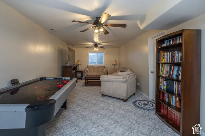 Recessed lighting, patterned carpeting, multiple ceiling fans, and a window with blinds.