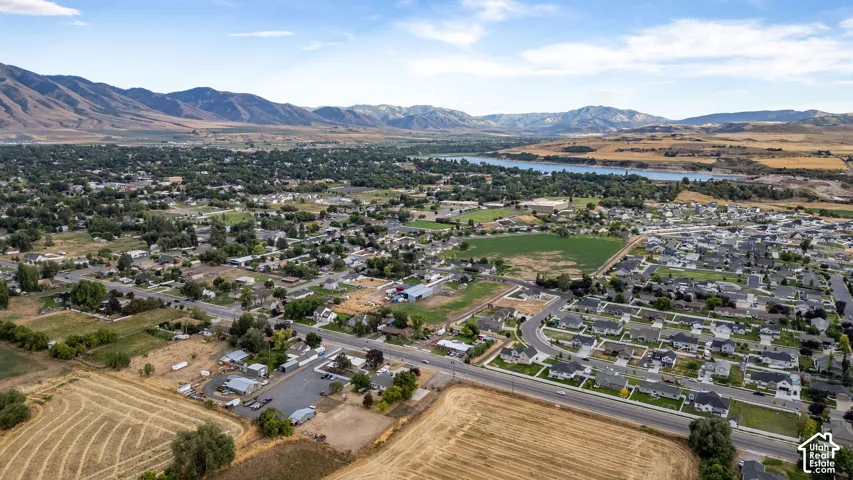 Expansive neighborhood setting with established homes, a lake, and distant mountains.