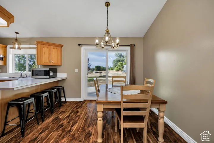 Wood-finish flooring, white countertops, light wood cabinetry, and a glass-paneled sliding door