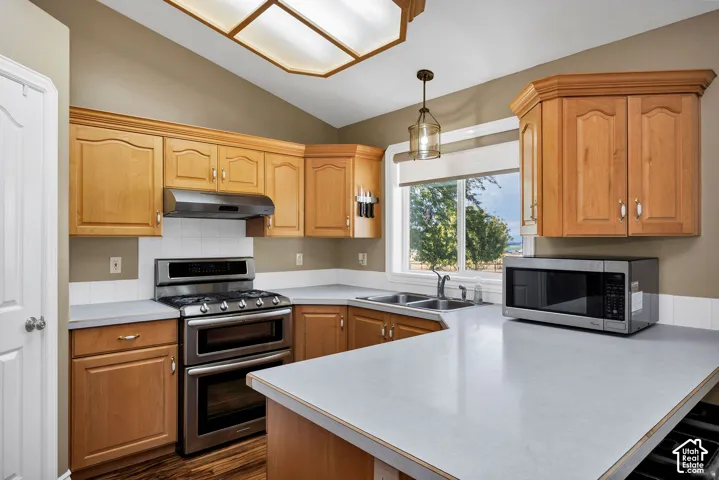 Kitchen featuring wood-finish cabinetry, stainless steel double oven range, and white countertops