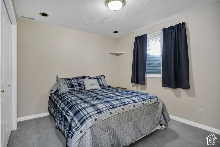Neutral-toned walls, recessed lighting, and a window with blinds.