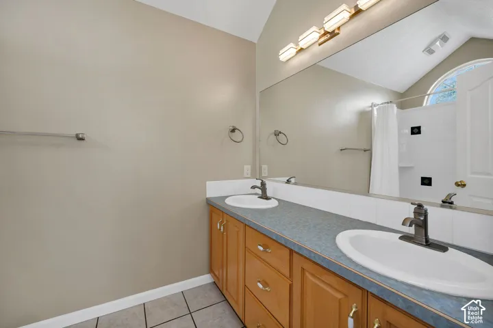 Dual vanity featuring wood-finish cabinetry and integrated sinks
