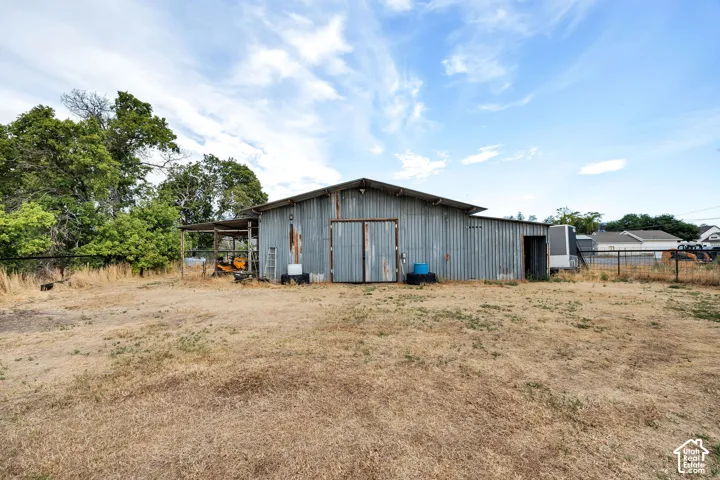 Corrugated metal barn with a pitched roof and covered side extension.