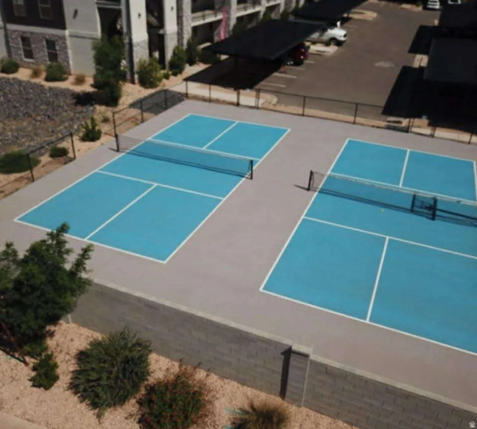 Two pickleball courts with blue playing surfaces and white line markings