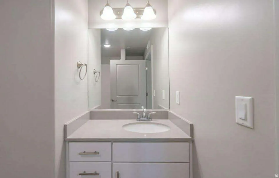 Vanity with integrated sink, stone-finish countertop, and undermount cabinetry