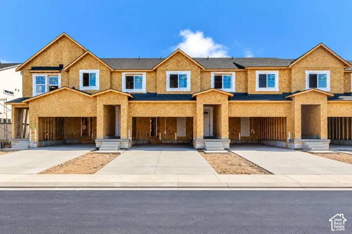Multi-unit structure featuring oriented strand board exterior cladding, dark shingle roofing, multi-gable roofline, concrete entry stoops, and individual concrete driveways