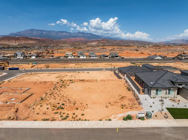 Expansive land plot with mountain backdrop and clear skies