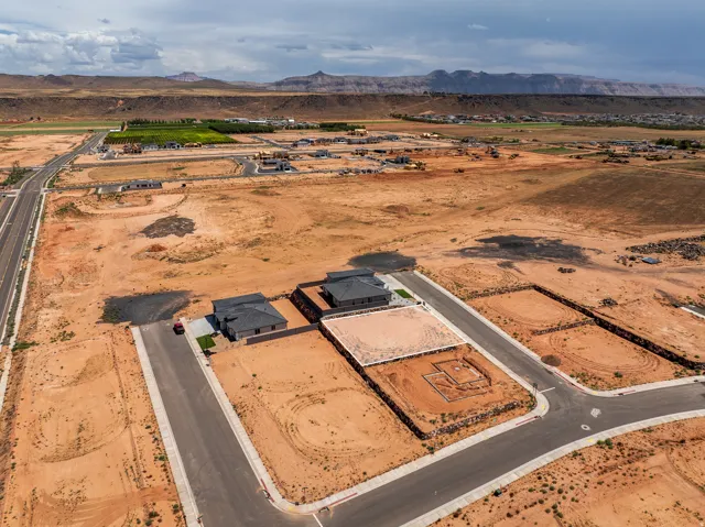 Expansive land parcel within a developing community, featuring an established street grid and foundational construction