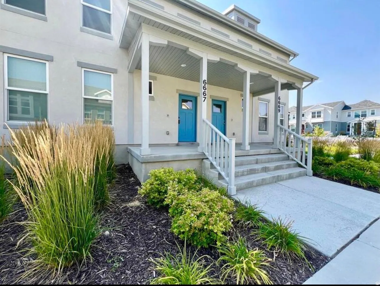 Contemporary stucco exterior with a covered porch featuring decorative columns