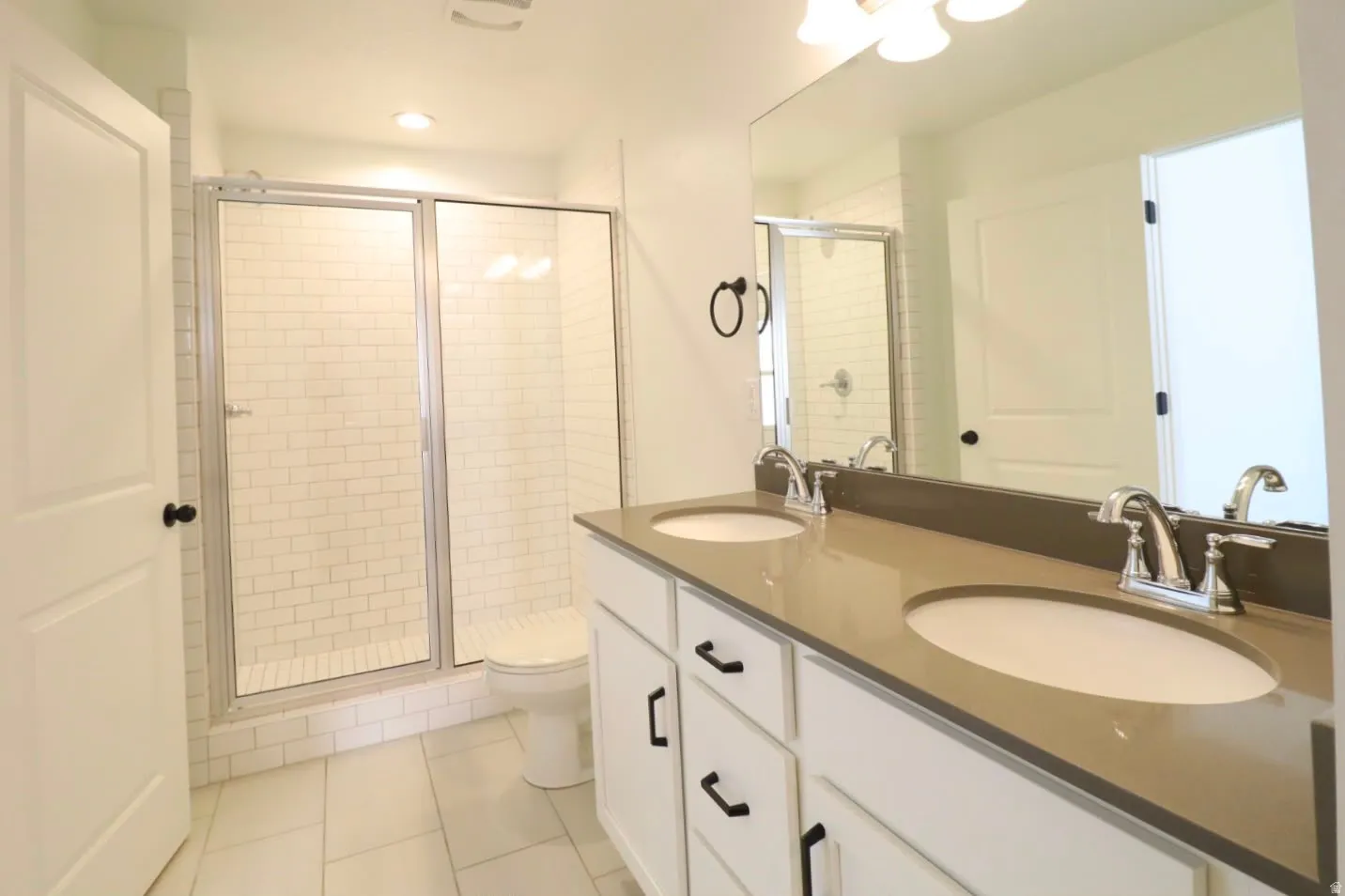 Dual vanity with undermount sinks, stone countertop, and chrome fixtures