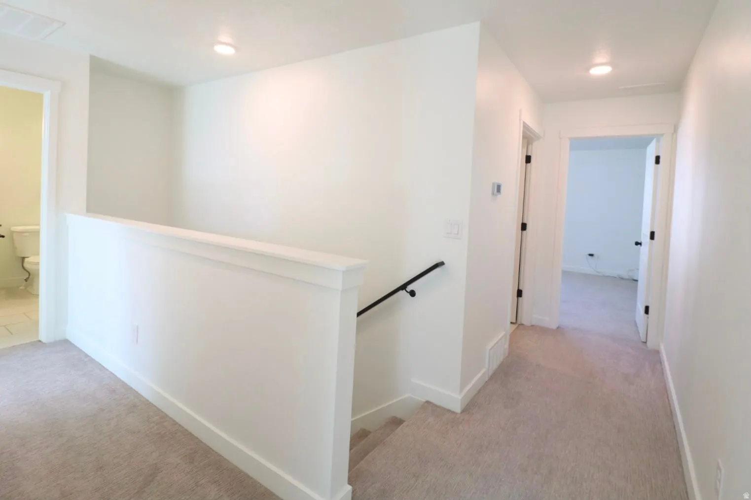 Neutral-toned carpeting throughout upper level and hallway