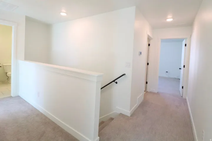 Neutral-toned carpeting throughout upper level and hallway