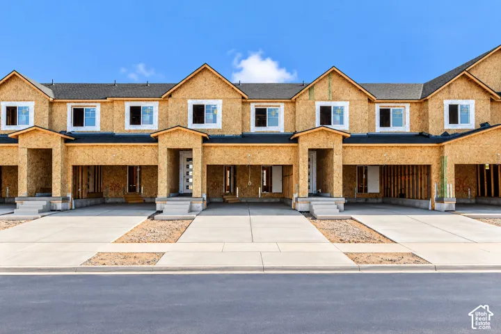 Multi-unit structure featuring shingle roofing, oriented strand board siding, concrete driveways, and white-framed windows