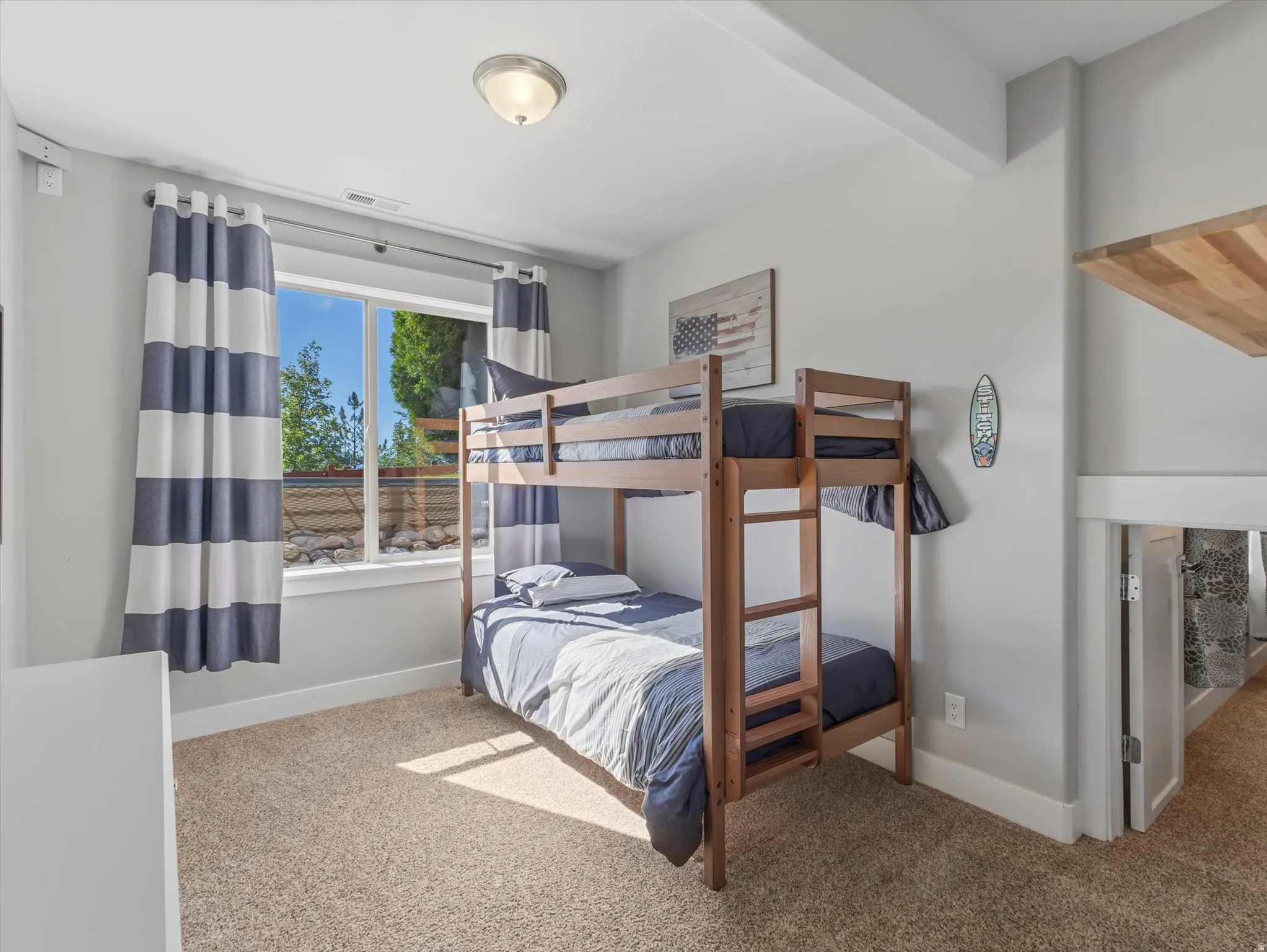Recessed window with exterior landscaping, light-toned carpeting, and a flush-mount ceiling light fixture