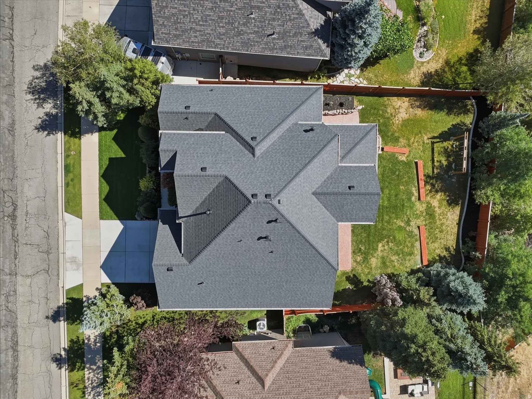 Multiple-pitch roof, expansive rear yard, mature perimeter landscaping, concrete driveway, and established front lawn