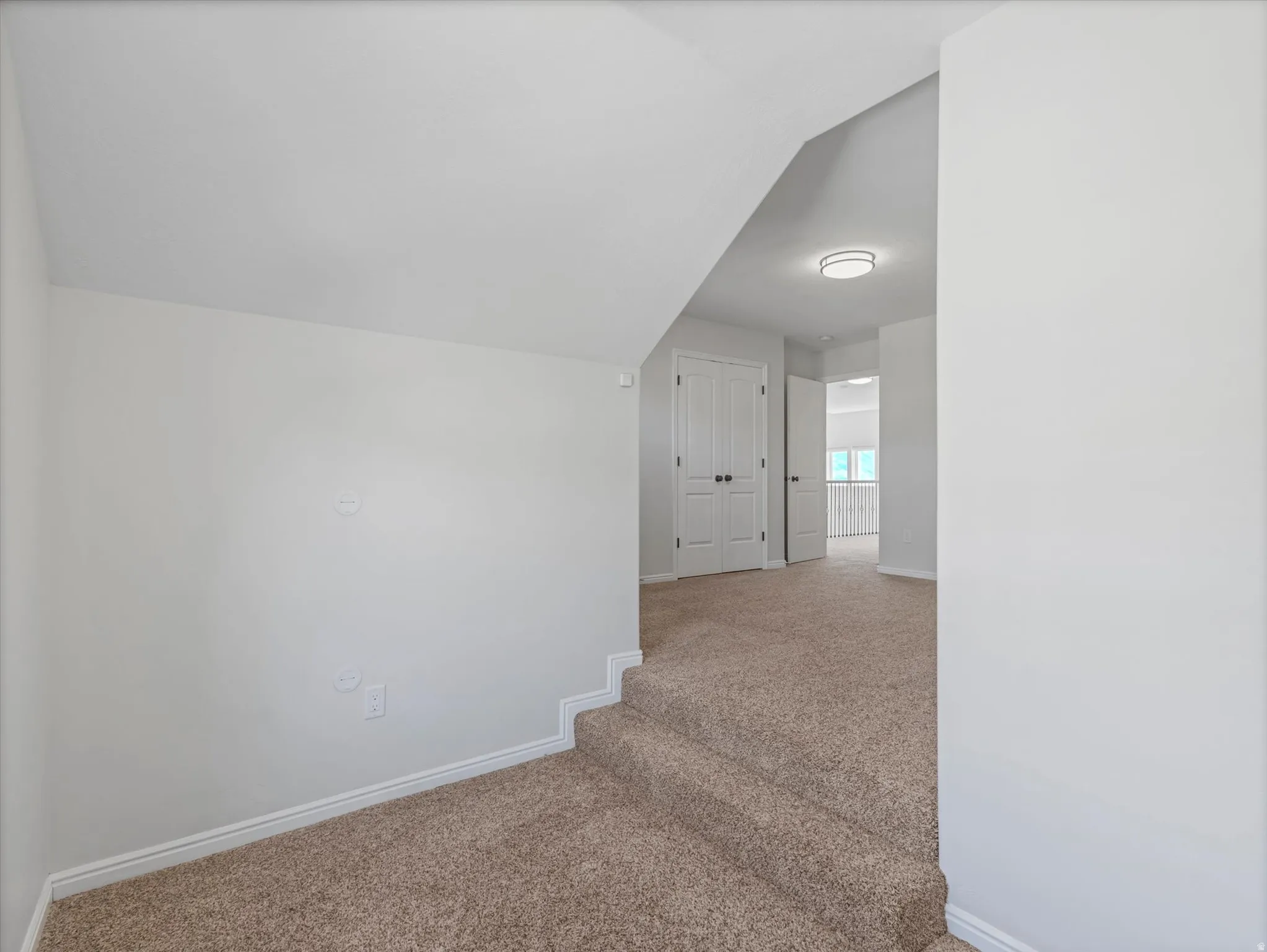 Neutral-toned carpeting throughout, crisp white walls, and a modern flush-mount ceiling light
