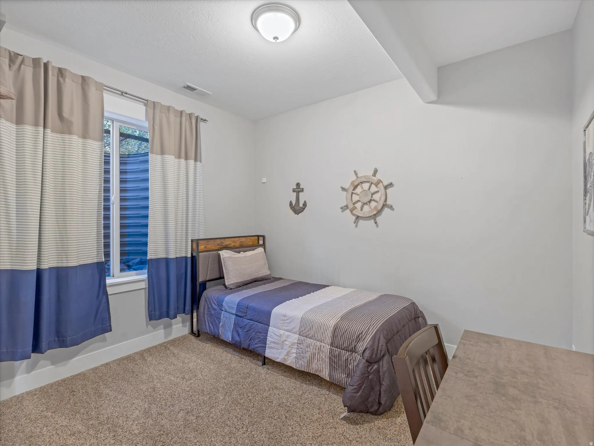 Carpeted room featuring a single window and an overhead flush-mount light fixture