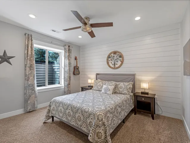 Recessed lighting, ceiling fan, carpet flooring, egress window, and horizontal wall paneling