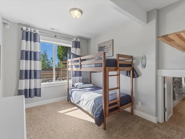 Recessed window with exterior landscaping, light-toned carpeting, and a flush-mount ceiling light fixture