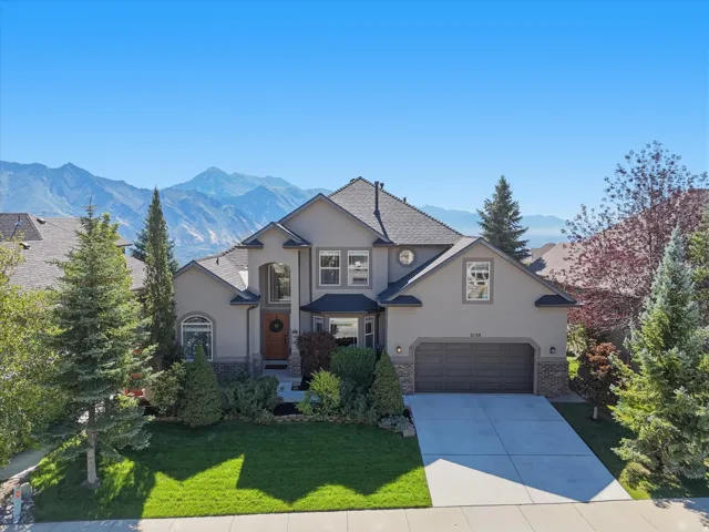 Stucco exterior with stone accents, a multi-pane front door, and an attached two-car garage